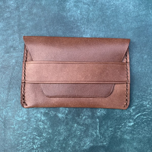 Brązowy portfel minimalistyczny ze skóry.