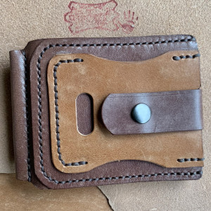 Brązowy portfel zapinany na klips ze skóry.