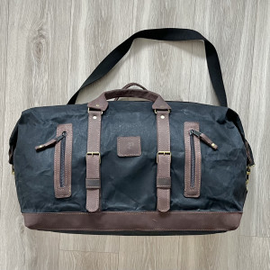 Duża czarno-brązowa torba podróżna z bawełny i skóry.