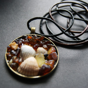 Wisior muszelka, bursztyn, metal, rzemień. średnica 4 cm